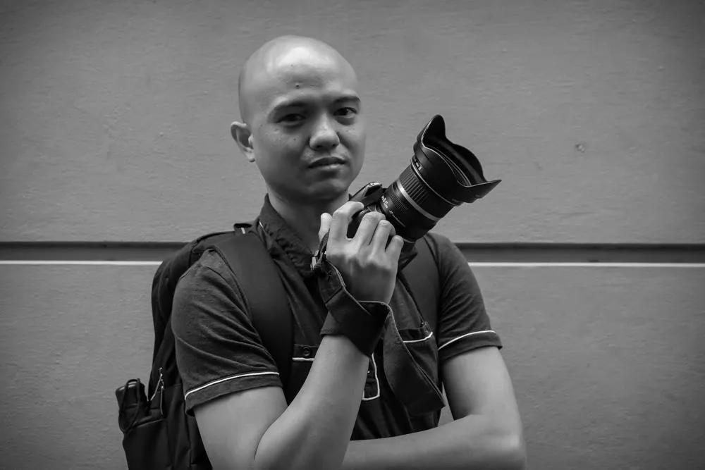 Robert Yap with cinema camera equipment in a black-and-white portrait.