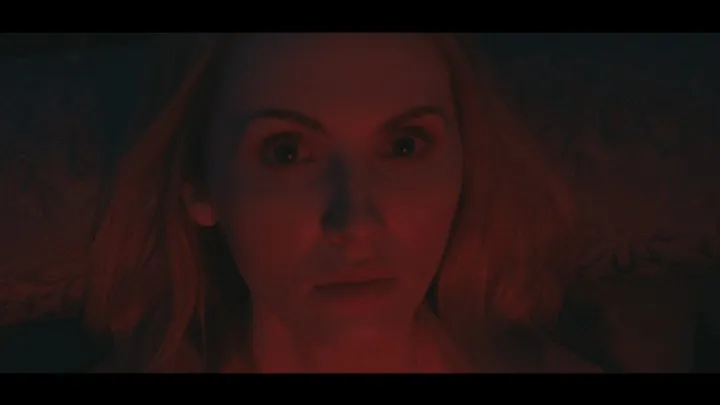A couple face one another in a red and blue room.