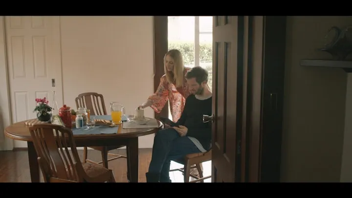 A couple sit together in a quiet living room.